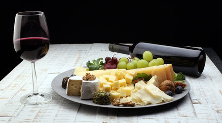 Cheese platter with different cheese and grapes and red wineの写真素材