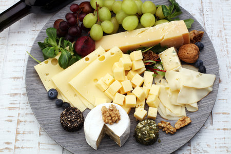 Cheese platter with different cheese and grapes and red wineの写真素材