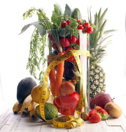 Healthy lifestyle concept. measuring tape sport fitness equipment and healthy food (fruits and vegetables, dumbells, apple, kiwi, pineapple,lemon strawberry, tomato, cucumber, onions, paprika, carrotの写真素材