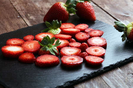 Fresh strawberries array heart shape on old wooden backgroundの写真素材