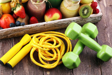 Healthy lifestyle concept. sport fitness equipment-several bottles with fruit and berry juices smoothies and milkshakes , jumping ropeの写真素材