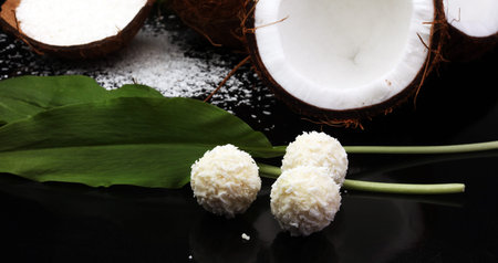 Coconut with leaves and coconut macaroons on black backgroundの写真素材