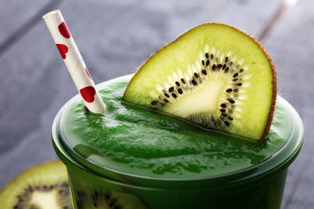 Healthy green smoothie from spinach and kiwi on a wooden tableの写真素材