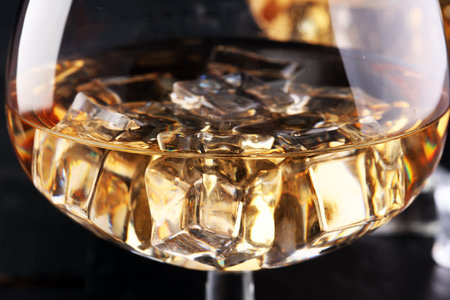 glass of whiskey with ice on a woodenの写真素材