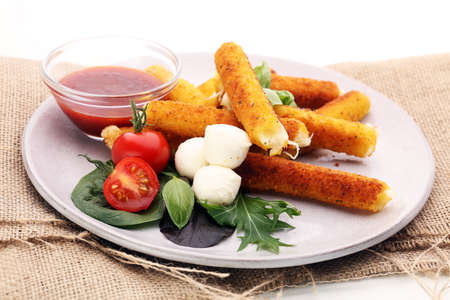 Breaded mozzarella cheese sticks with tomato ketchup and mozza ballsの写真素材