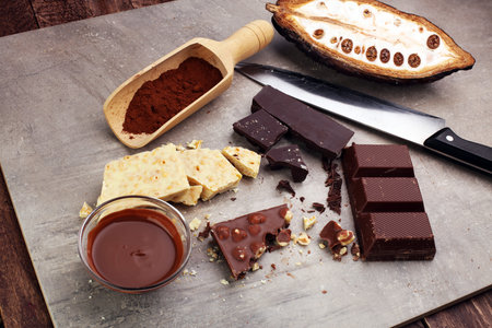 Melting chocolate and diffrent bars - stack and chips with chocolate swirl/ powder and cocoa podの写真素材
