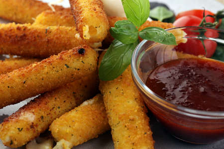 Breaded mozzarella cheese sticks with tomato ketchup and mozza ballsの写真素材