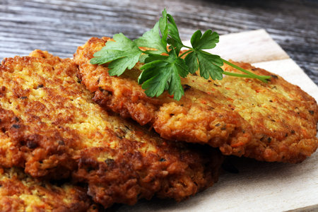 potato pancakes decorated with parsley on a cutting board on the tableの写真素材