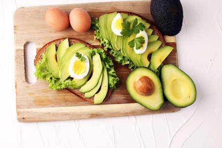 Sandwich with avocado and poached egg - healthy breakfast conceptの写真素材