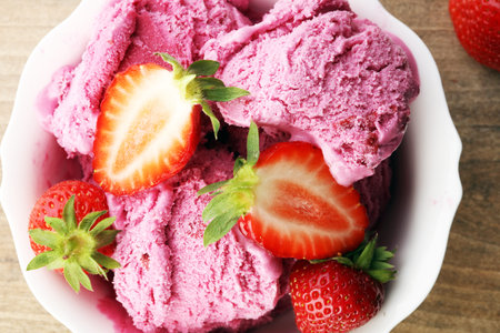 Strawberry ice cream on brown wood background
