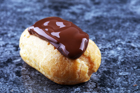 Traditional French dessert. Eclair with chocolate icing. Pastery concept