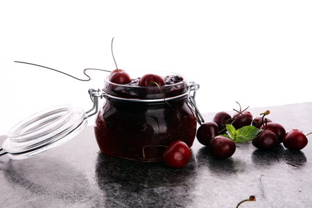 Jar of cherry jam, sour cherries and spoonの写真素材