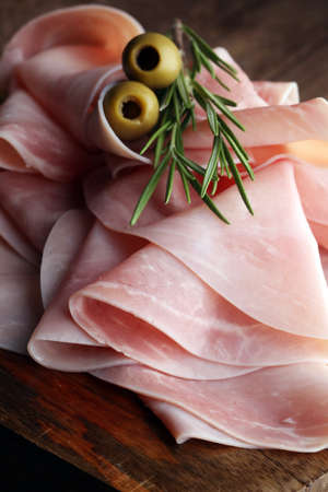 Sliced ham on wooden background. Fresh prosciutto. Pork ham sliced.の写真素材