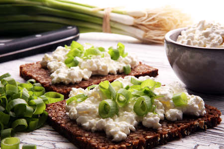 Cream Cheese on a slice of bread topped with fresh green onions or spring onionsの写真素材