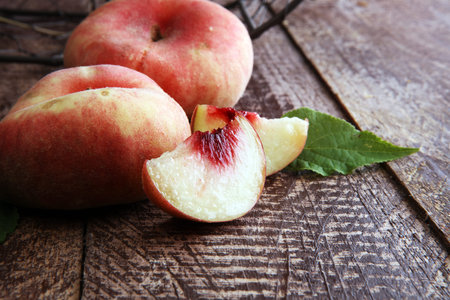 Ripe peaches in basket on wooden backgroundの写真素材