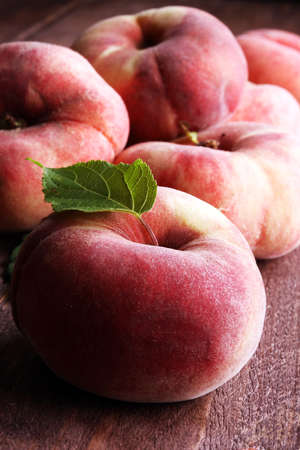 Ripe peaches in basket on wooden backgroundの写真素材