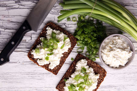 Cream Cheese on a slice of bread topped with fresh green onions or spring onionsの写真素材