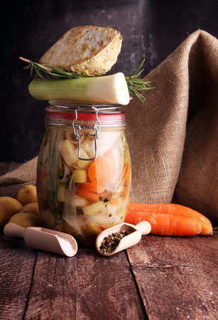 Jar with variety of pickled vegetables. Carrots, field garlic, parsley in glas. Preserved foodの写真素材