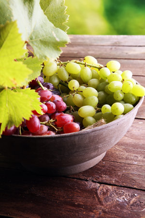 Grapes on wooden table and grape leaves . Healthy fresh fruit wine grapes.の写真素材