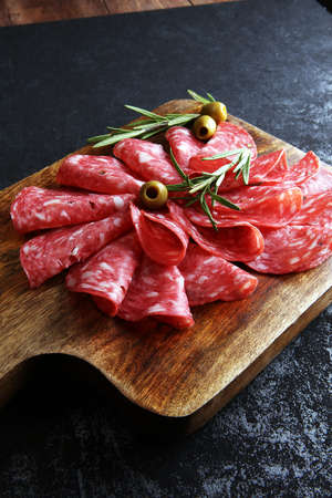 thinly sliced salami on a wooden cuttingboardの写真素材