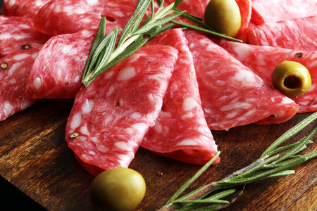 thinly sliced salami on a wooden cuttingboardの写真素材