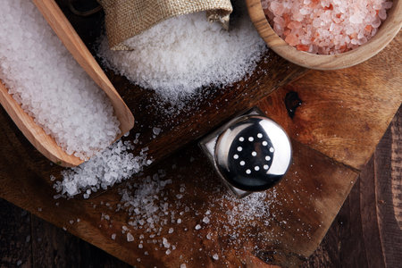 Salt Shaker and salt on wooden table.の写真素材