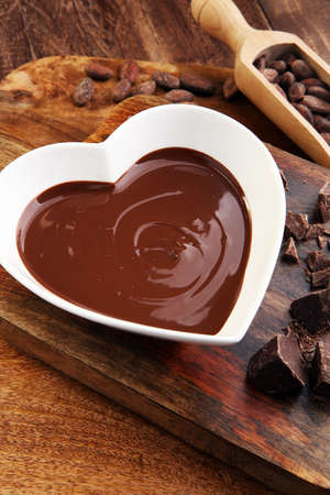 Chocolate cream and chocolate pieces on wooden tableの写真素材