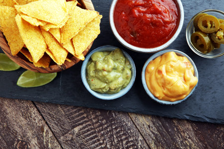 Nachos Tortilla Chips and jalapeÒos Chili Peppers or Mexican chili peppers with Tomato, Cheese and Guacamole dip.の写真素材