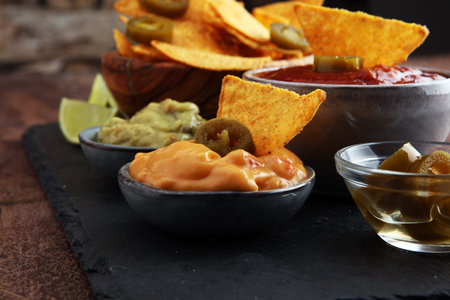 Nachos Tortilla Chips and jalapeÃ’os Chili Peppers or Mexican chili peppers with Tomato, Cheese...