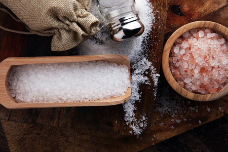 Salt Shaker and salt on wooden table.