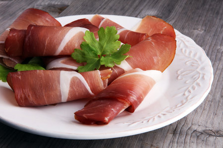Italian prosciutto crudo or jamon. Raw ham on white dishの写真素材