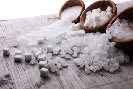 Bowl with white sand, crystal and lump sugar on wooden background.の写真素材