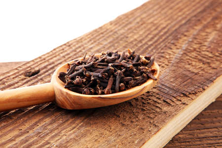 Many Dry cloves spice on brown wooden spoon.の写真素材