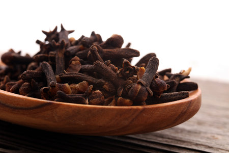 Many Dry cloves spice on brown wooden spoon.の写真素材