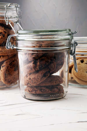 Chocolate cookies in a glass jar on white background.の写真素材