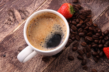 coffee, strawberries and beans on brown wooden backgroundの写真素材