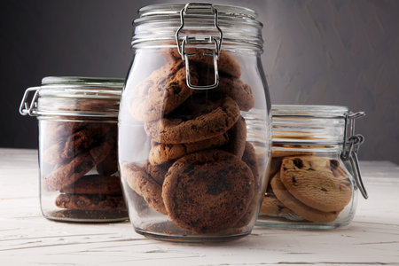 Chocolate cookies in a glass jar on white background.の写真素材