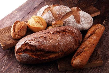bakery concept with bread and bread rolls on wooden background.