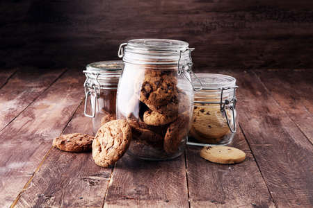 Chocolate cookies in a glass jar on white background.の写真素材