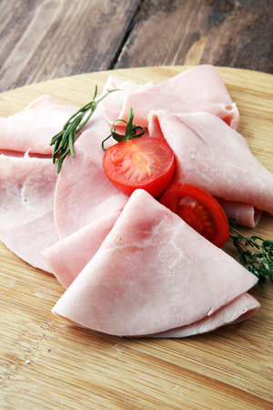 Sliced ham on wooden background. Fresh prosciutto. Pork ham slicedの写真素材
