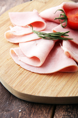 Sliced ham on wooden background. Fresh prosciutto. Pork ham slicedの写真素材