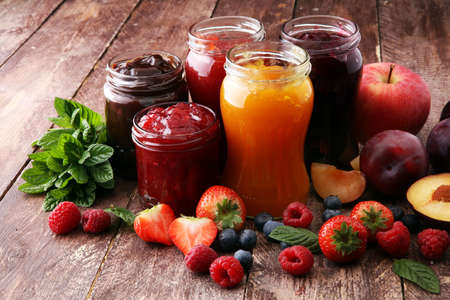 assortment of jams, seasonal berries, plums, mint and fruits の写真素材