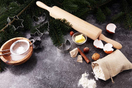 Baking ingredients for homemade pastry on wooden background with cookies and spieces.の写真素材