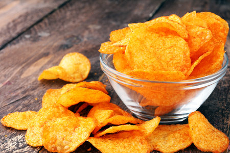 Crispy potato chips in a bowl. Tasty paprika chips.