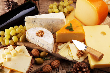 various types of cheese on rustic wooden table
