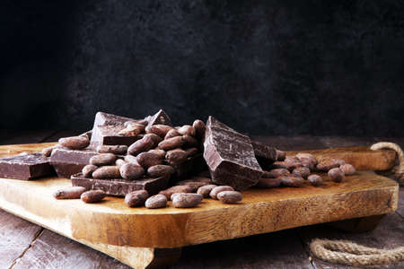 Dark chocolate pieces, stacks and cocoa beans, culinary background.の写真素材