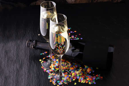 New Year concept with champagne in glass and bottle and confettiの写真素材
