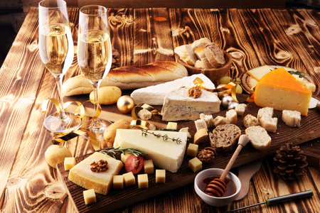 Different types of cheeses on board with walnut and grapes