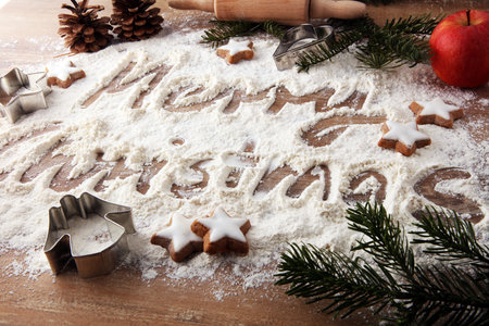 Christmas composition. Merry christmas text made with flour on black background and cookies