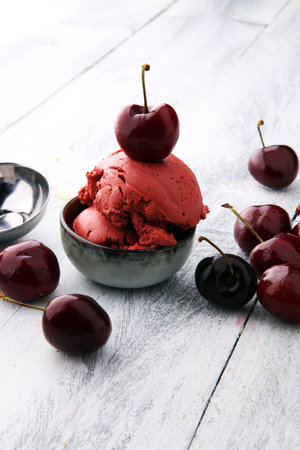 Homemade cherry ice cream on wooden background with fresh cherries
